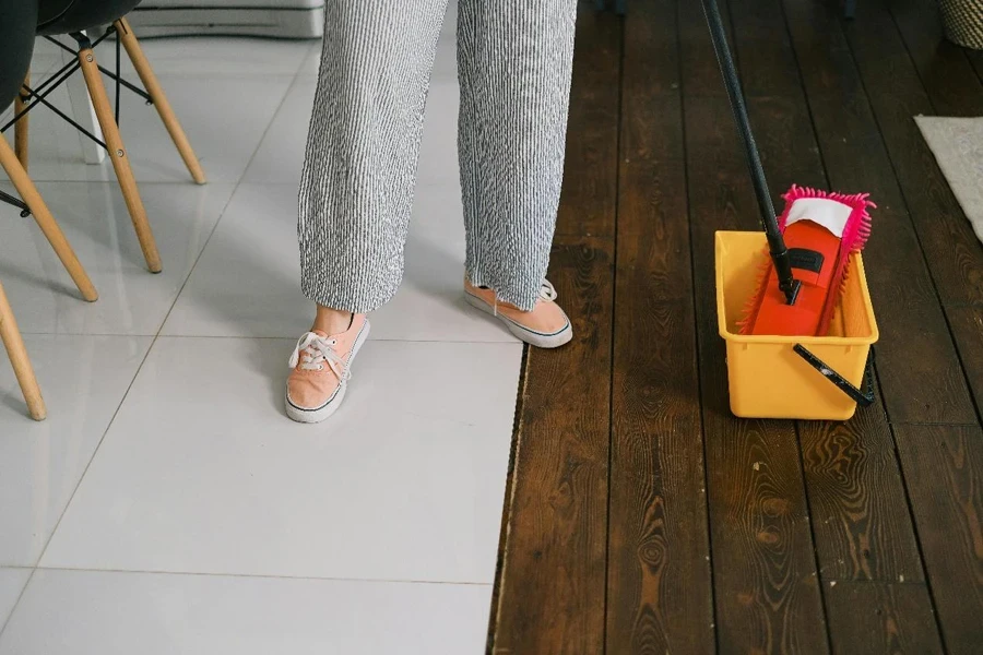 Faceless housewife preparing to wash floor at home