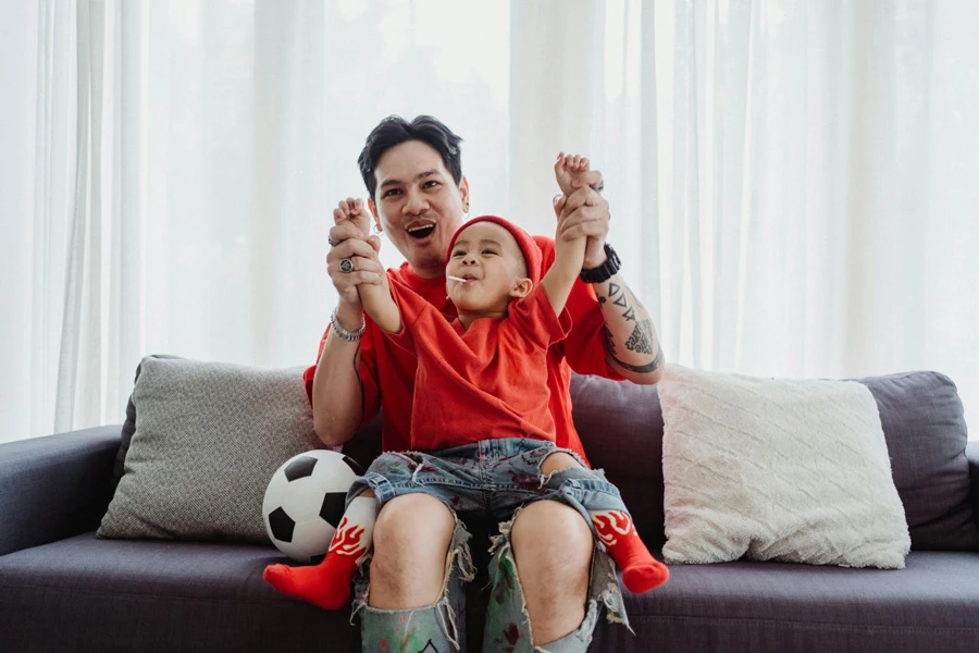 Father and Son Dressed in Red Playing on Sofa