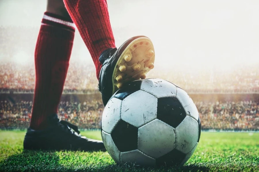 Feet of soccer player tread on soccer ball for kick-off in the stadium