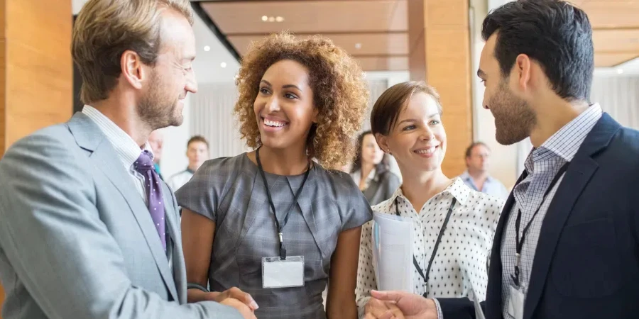 Four business people shaking hands at beginning of meeting