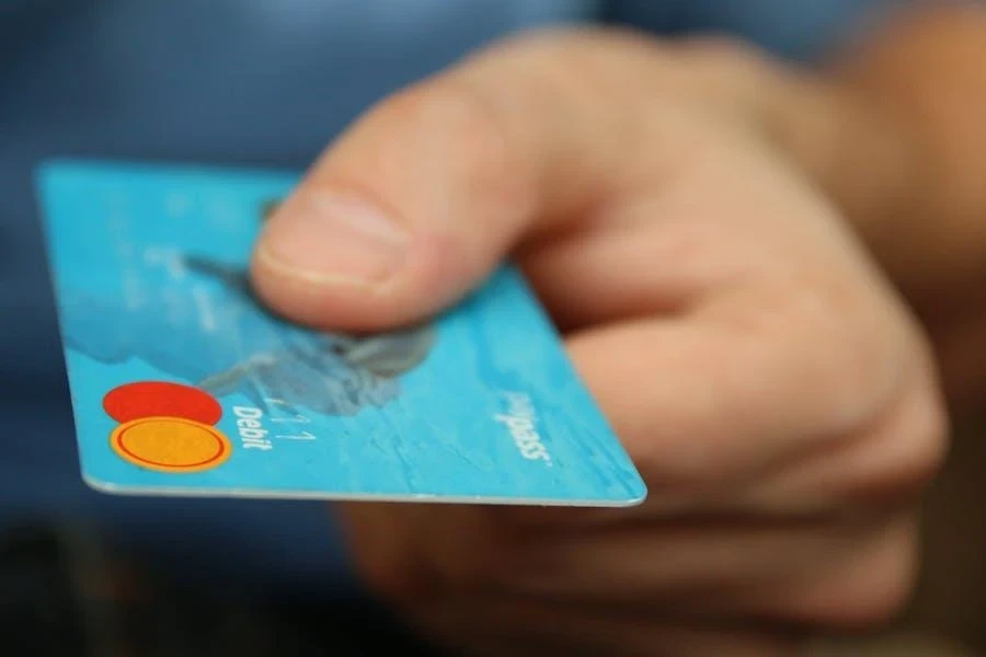 Hand holding a blue credit card