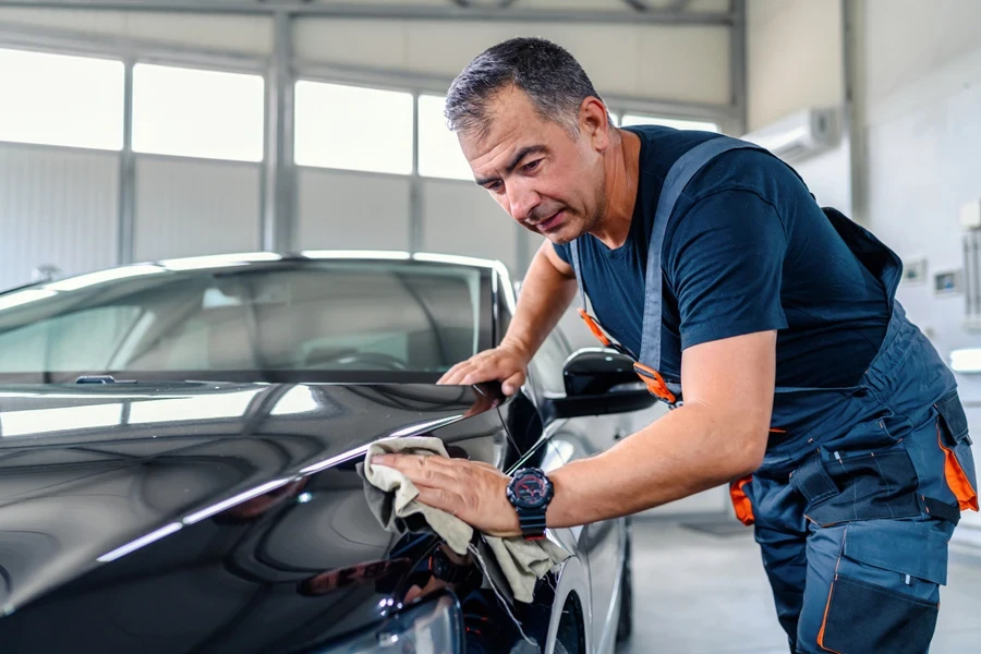 Hands with orbital polisher in the auto repair shop