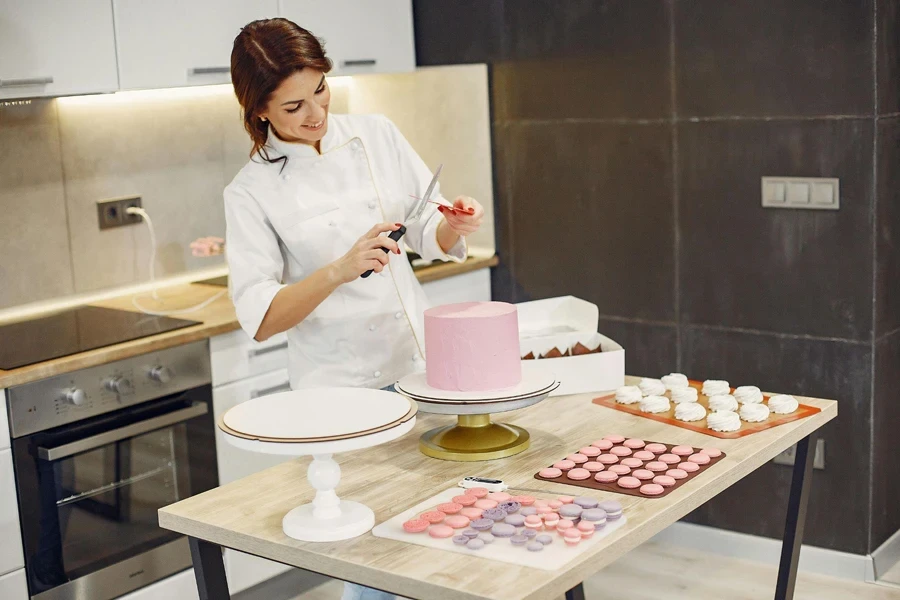 Happy woman preparing kitchen tools during process of making delicious desserts in confectionery