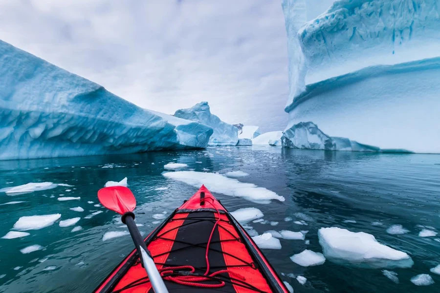 Kayaking in Antarctica between icebergs with inflatable kayak