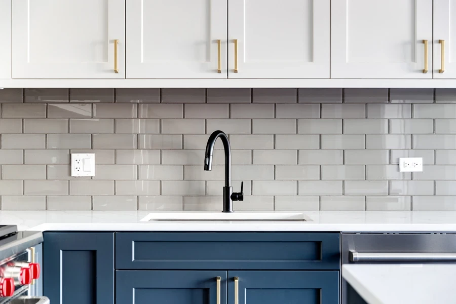 Kitchen with blue and white cabinet and subway kitchen backsplash