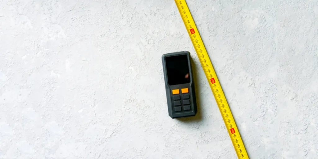 Laser tape measure on concrete background