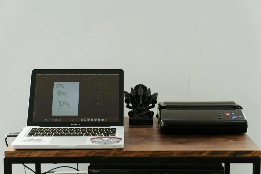 Macbook Pro beside a printer on a Brown Wooden Table