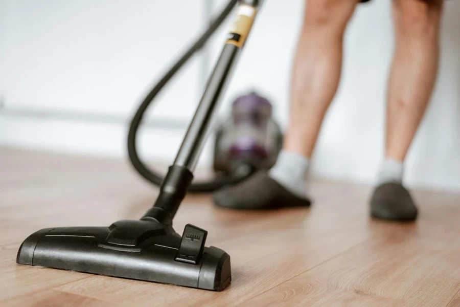 Man Cleaning Floor with Vacuum Cleaner