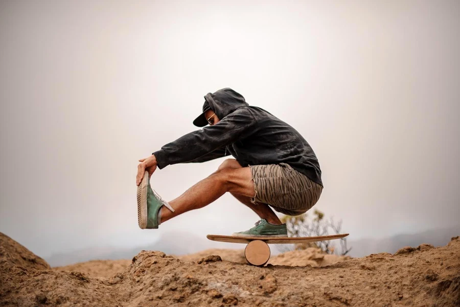 Man doing stunts with balance board on the mountain