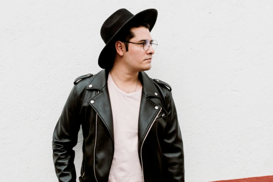 Man wearing a black leather hat, T-shirt, and jacket