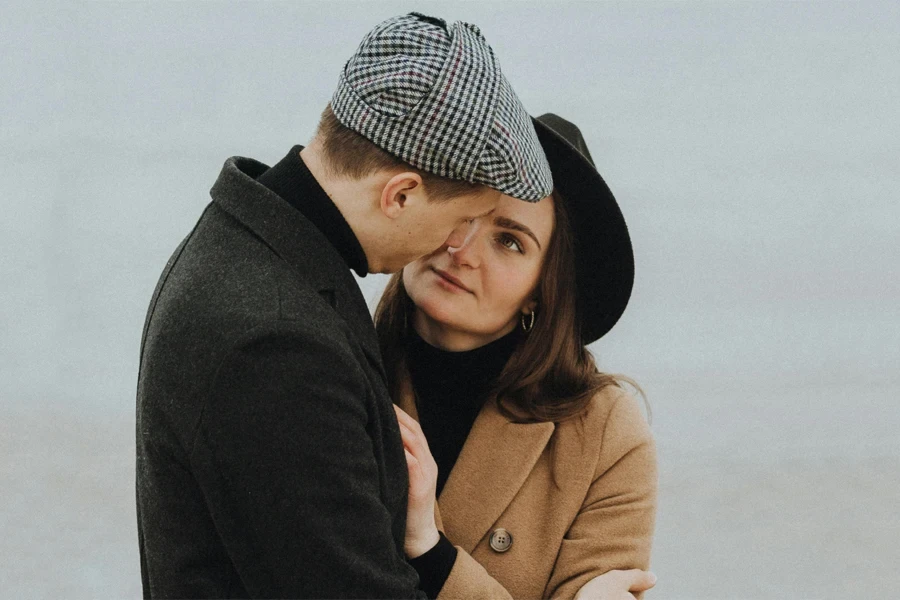 Man wearing a cap and woman wearing a fedora