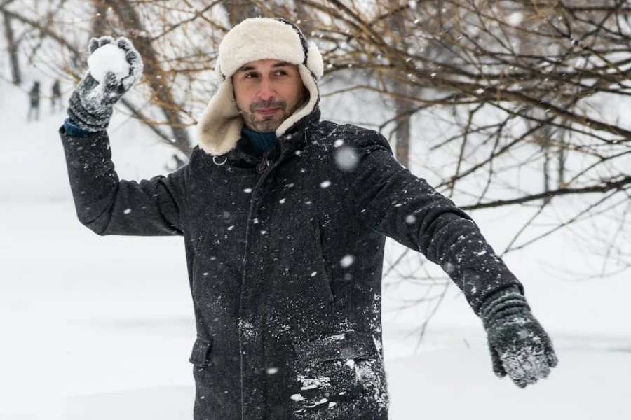 Man wearing a trapper hat in the snow