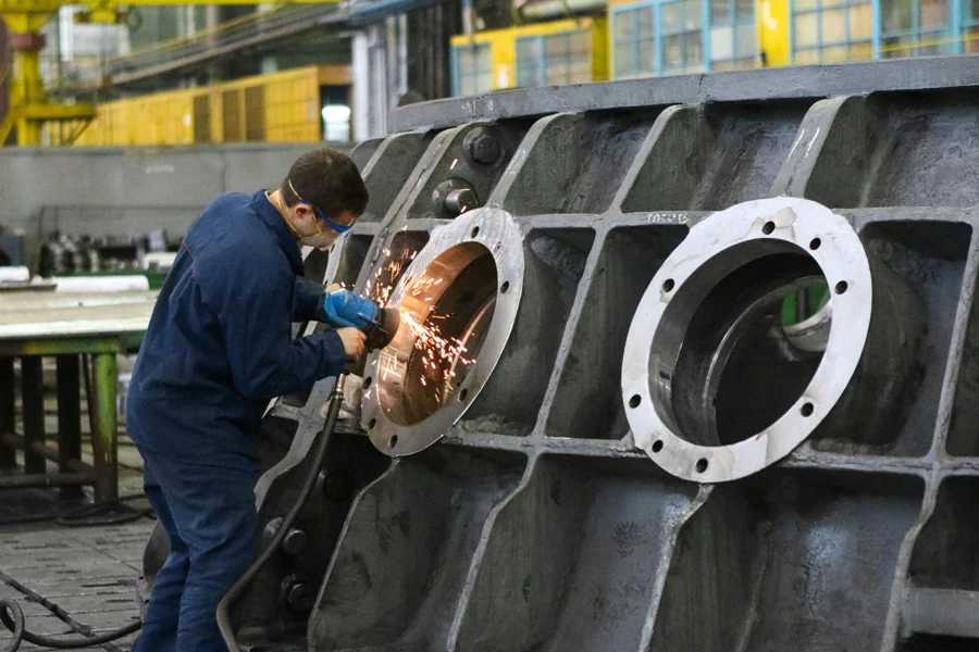 Man welding a round window frame