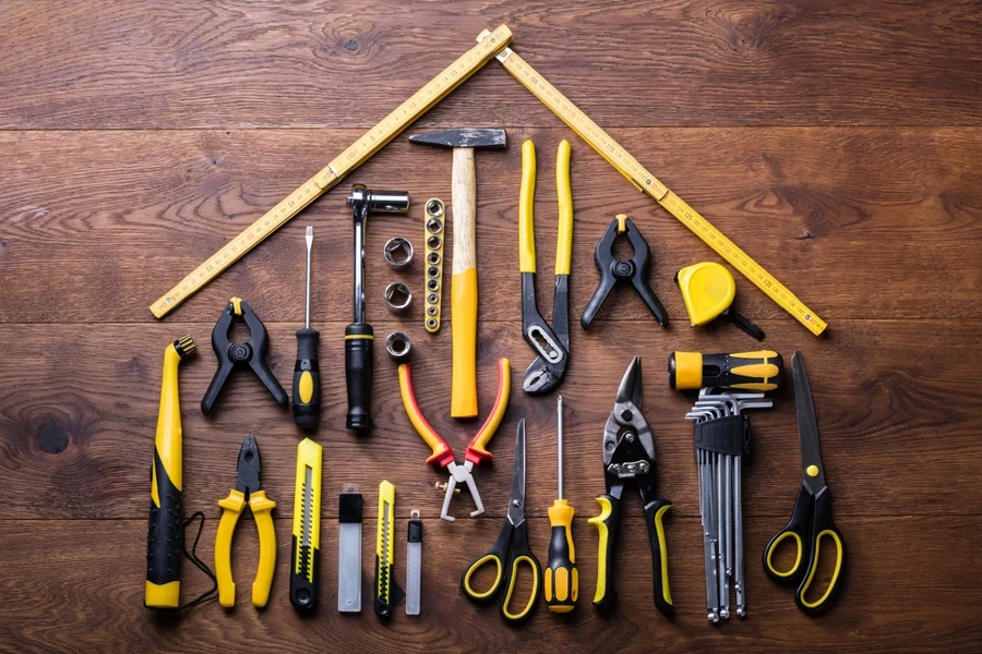 Many tools on a table with yellow measuring tape roof