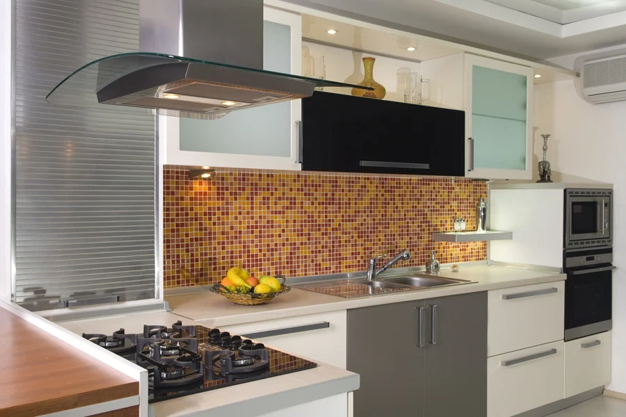 Modern kitchen with cooker, fruits and a mosaic style backsplash