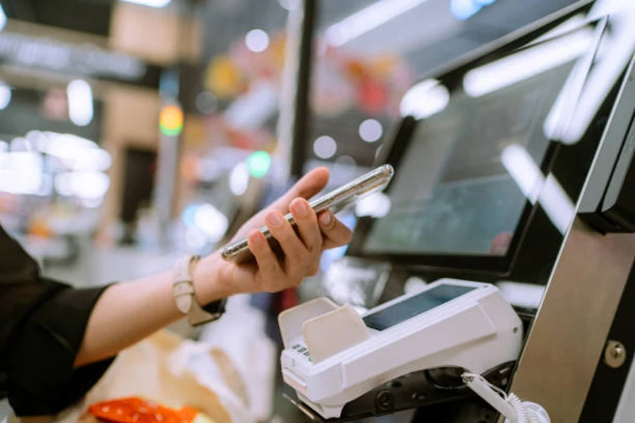 Person paying with a smartphone at a self-checkout station