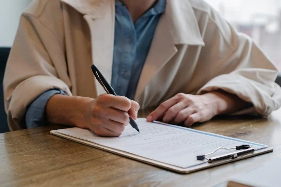 Person writing a list of sponsors on a clipboard