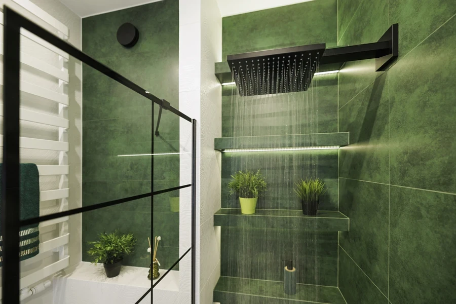 Rain shower in a bathroom with dark green tiles