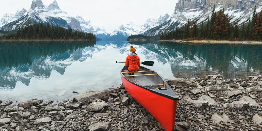 Scenery of Spirit Island with female traveler on kayak by the Maligne Lake