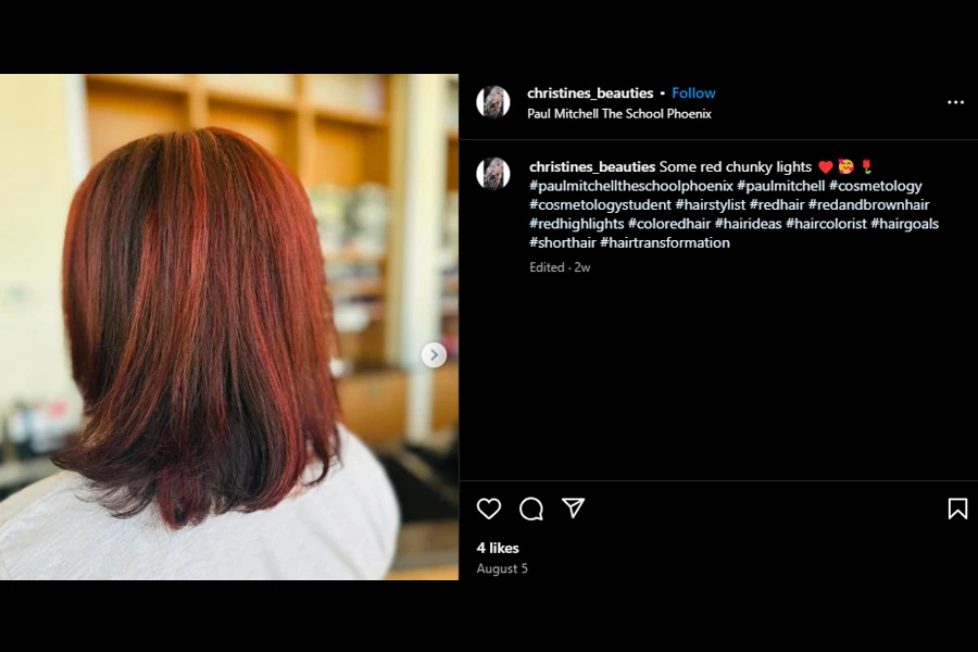 Screenshot of a woman rocking a cherry red wig with brown highlights