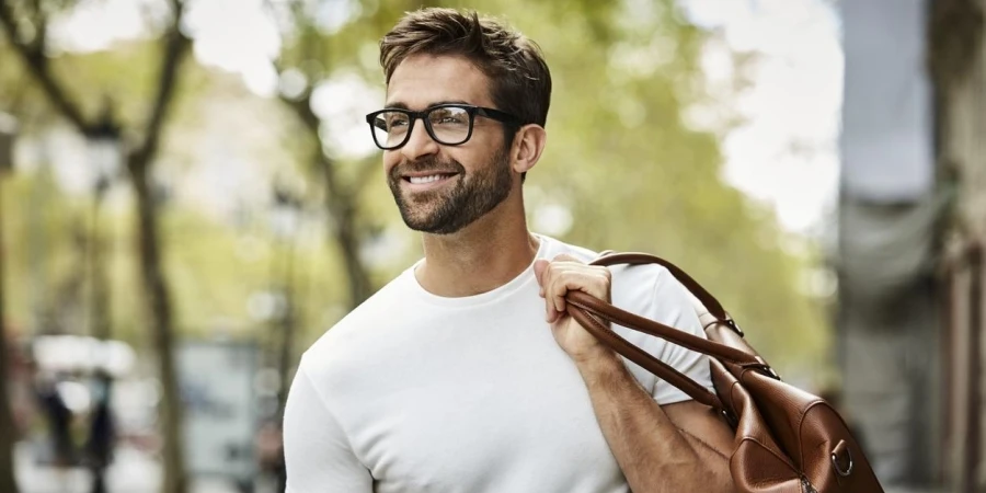 Smiling businessman with brown bag walking in city