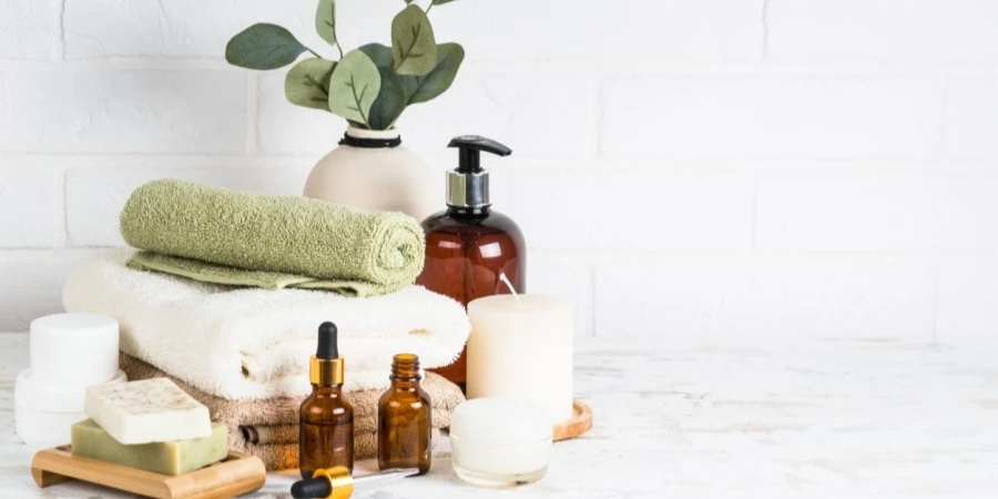 Stack of Towels, Shampoo Bottle, Candles, Essential Oil and Cosmetics