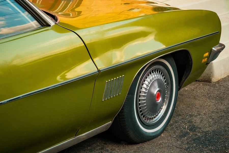 The Front Side Of An Olive Green Classic Car