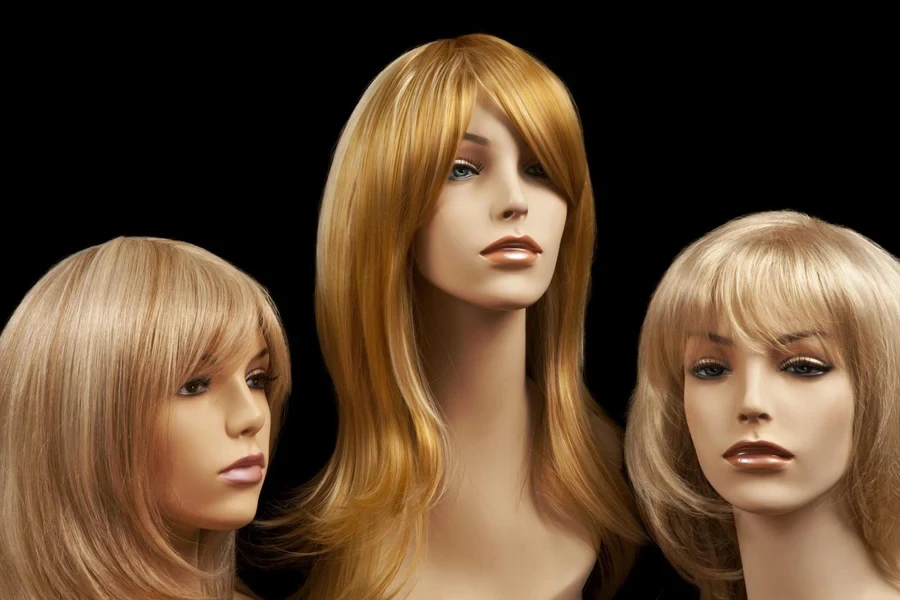 Three blonde mannequin heads with wigs