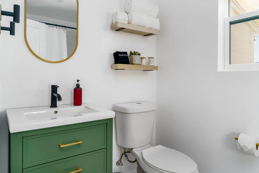 Tiered wooden shelves with towels over a toilet seat