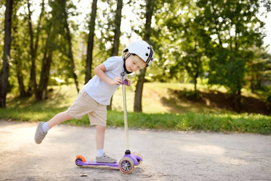 Toddler Boy in Safety Helmet Learning to Ride Scooter