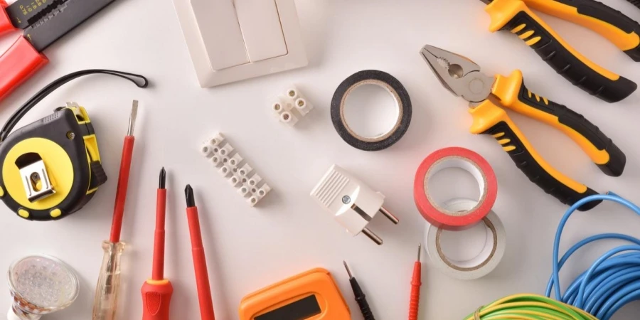 Tools and electrical material on a white table general view Horizontal composition