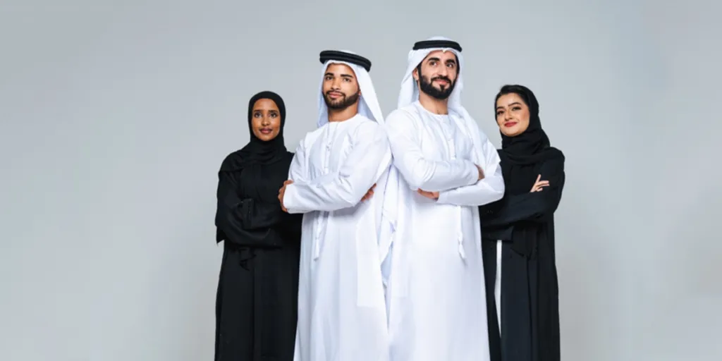 Two Arab men wearing thobes and women wearing black abayas