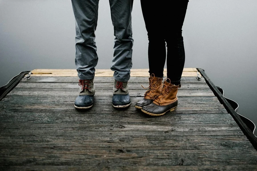 Two Person Wearing Black and Brown Duck Boots