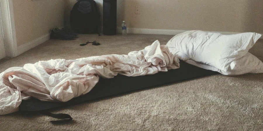 Two White Rectangular Pillows With White Blanket on Carpet