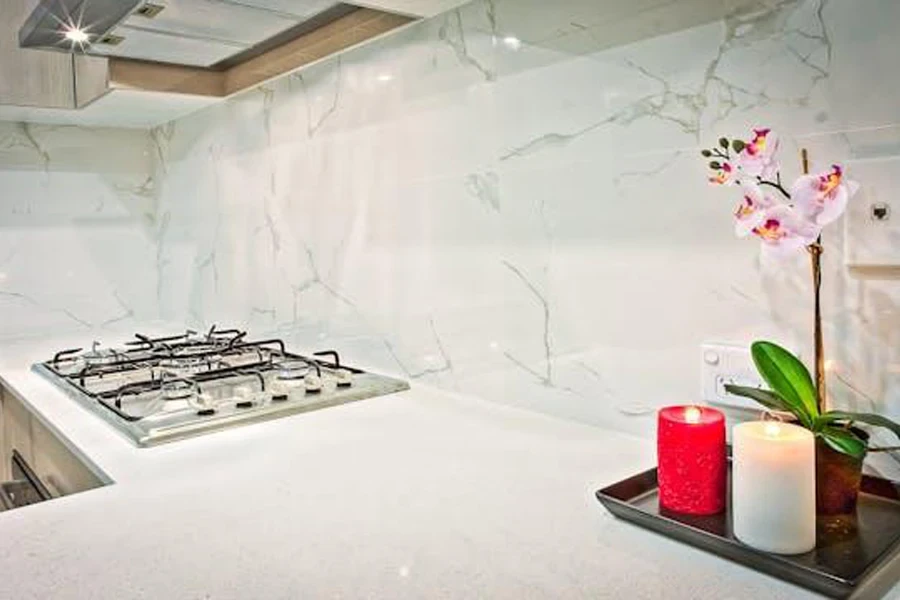 White kitchen backsplash tiles with gas cooker and candles