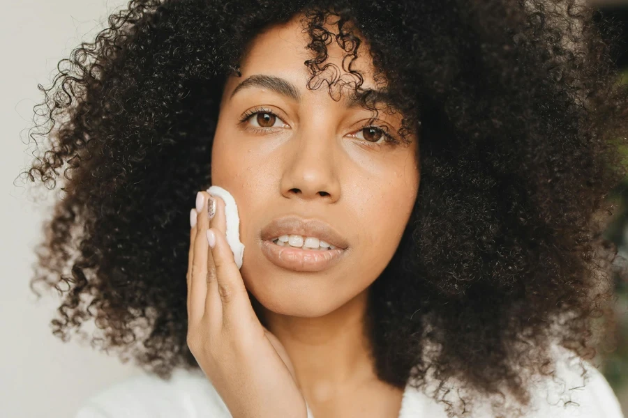 Woman Cleaning Her Face with Cotton Pad