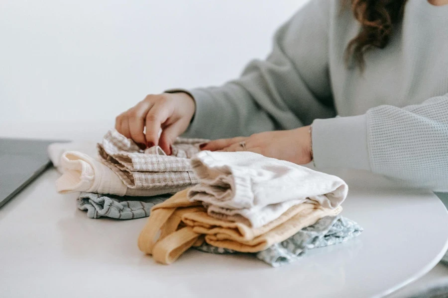 Woman Folding Baby’s Clothes