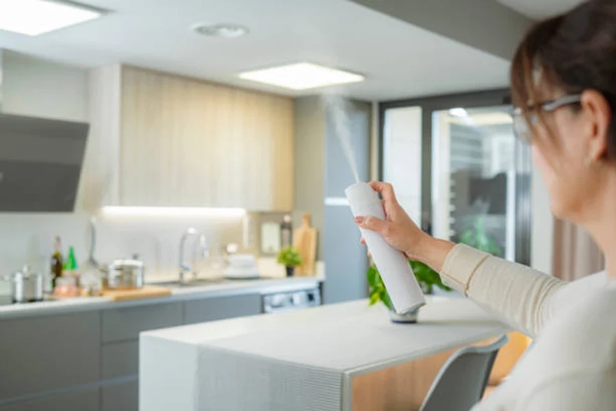 Woman Spraying Air Freshener in Her Kitchen