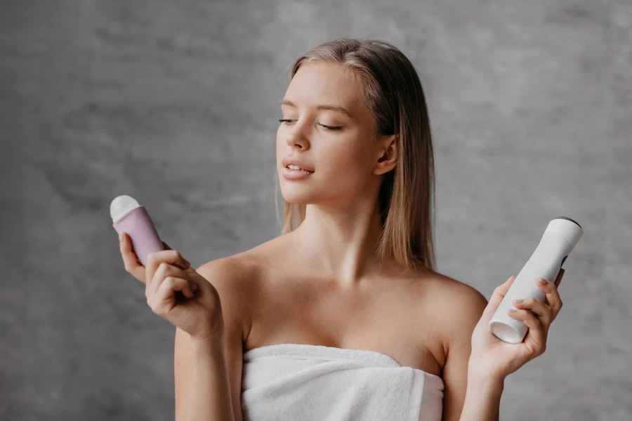 Woman choosing between roller and spray deodorants