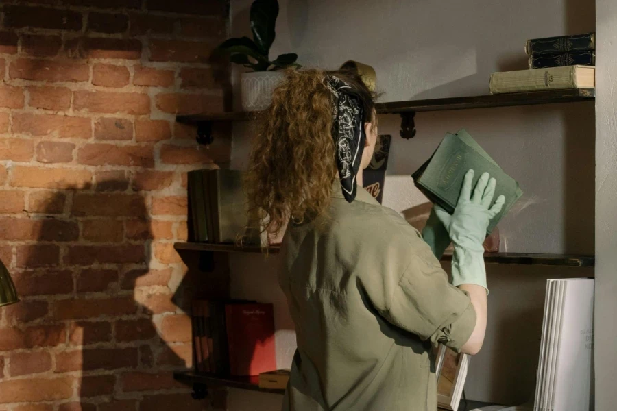 Woman in Green Jacket and Blue Denim Jeans Holding Green Box