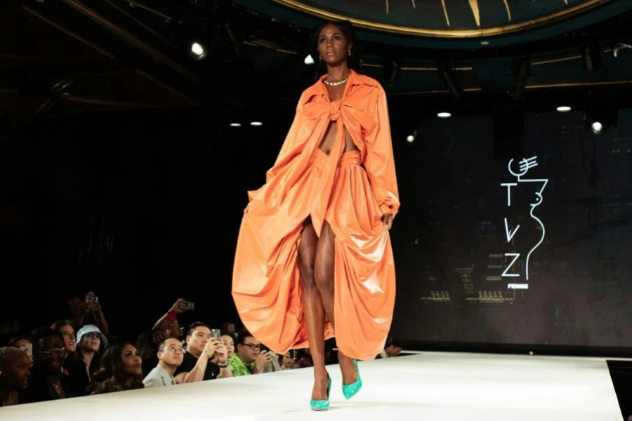 Woman in Orange Robe Standing on Stage