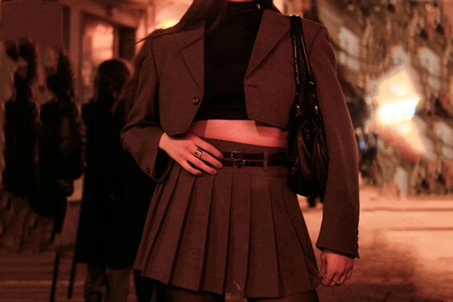 Woman in a cropped jacket and short pleated skirt