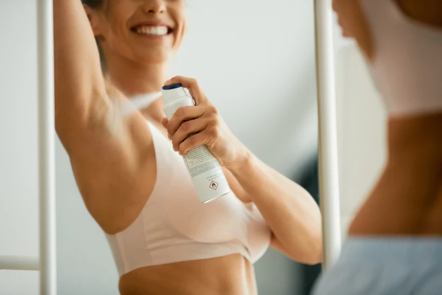 Woman spraying deodorant under her armpit