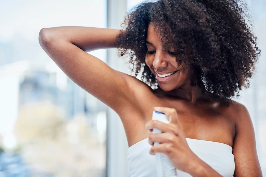 Woman using a deodorant spray