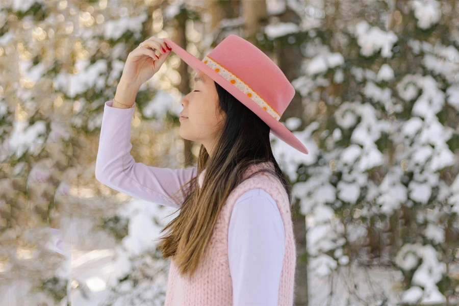 Woman wearing a flat-topped pink winter boater hat