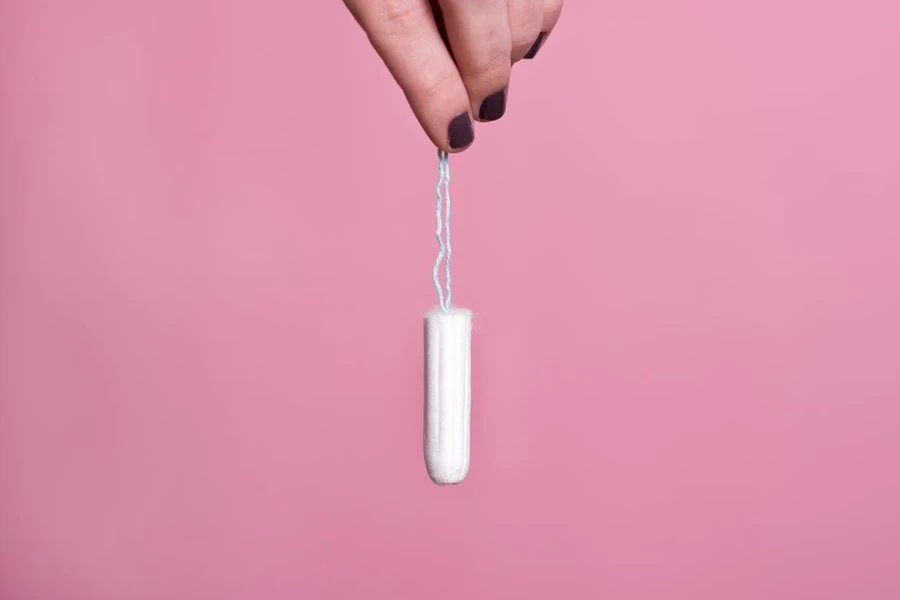 Woman's hand holding a clean cotton tampon