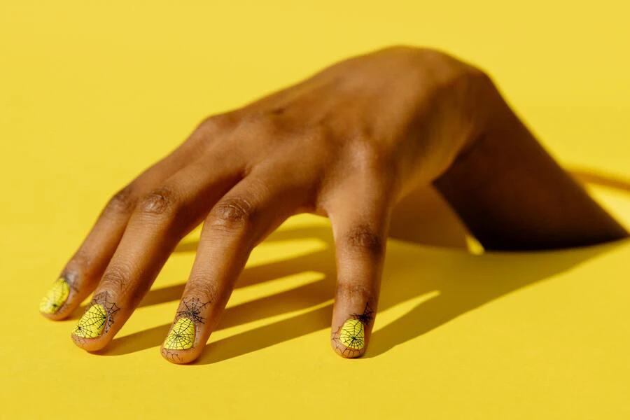 Yellow nails with black web-like designs