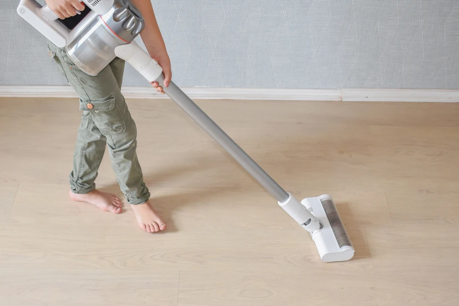 a girl cleaning the house with a portable vacuum cleaner