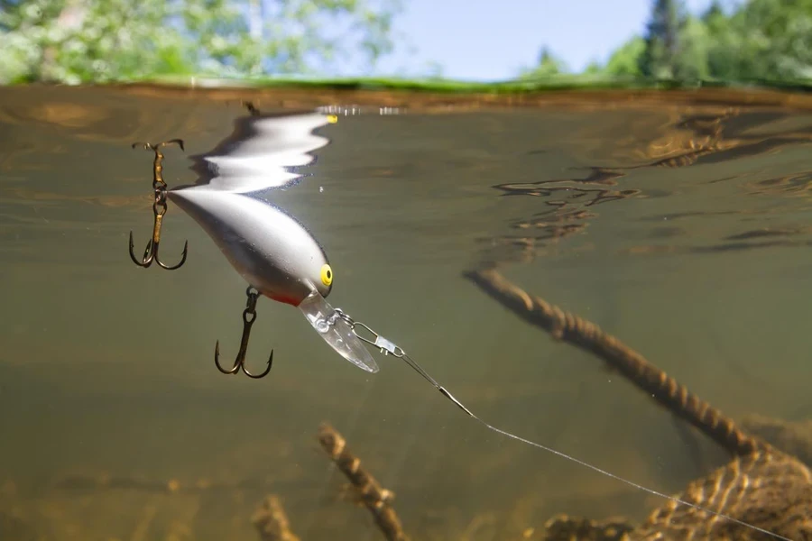 a light gray wobbler floats attached to a fishing line