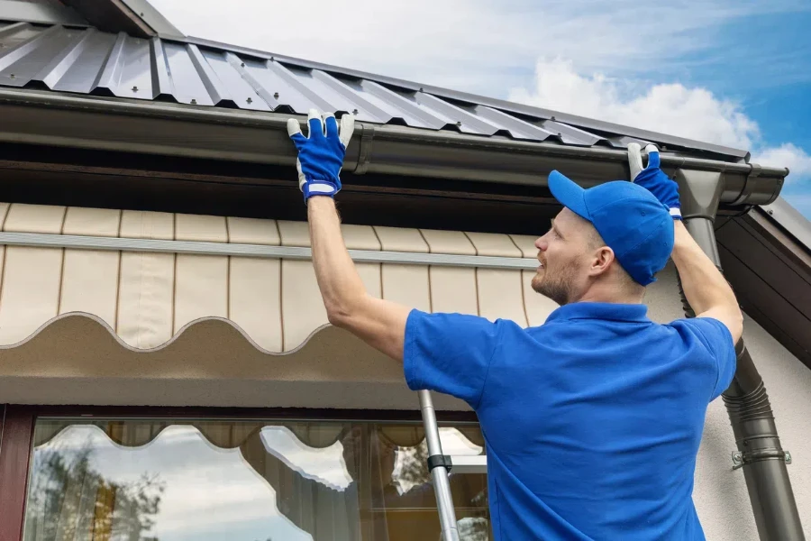 A man installing roof rain gutter